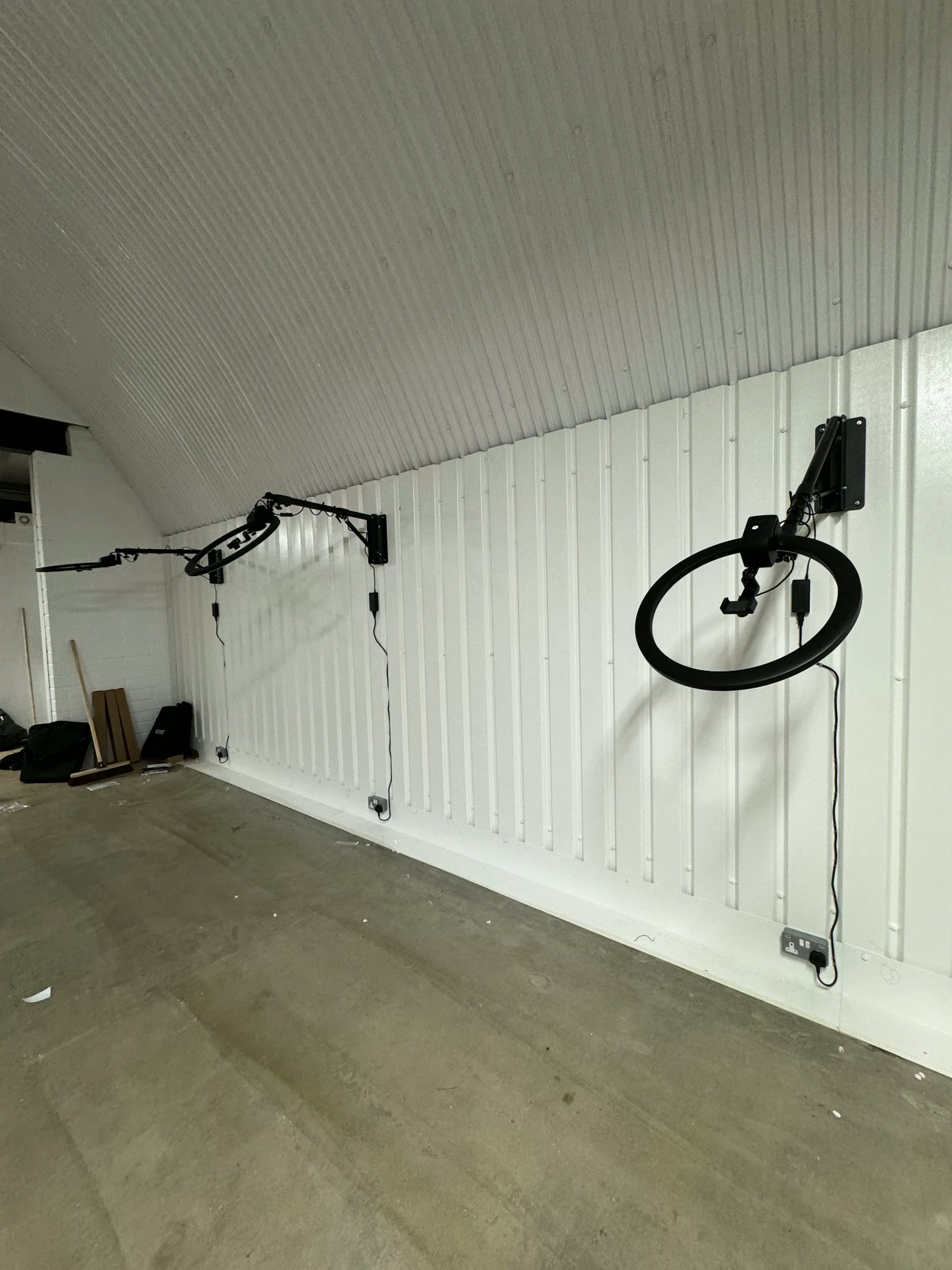 First ring light mounted on its articulated arm against the new white wall panels