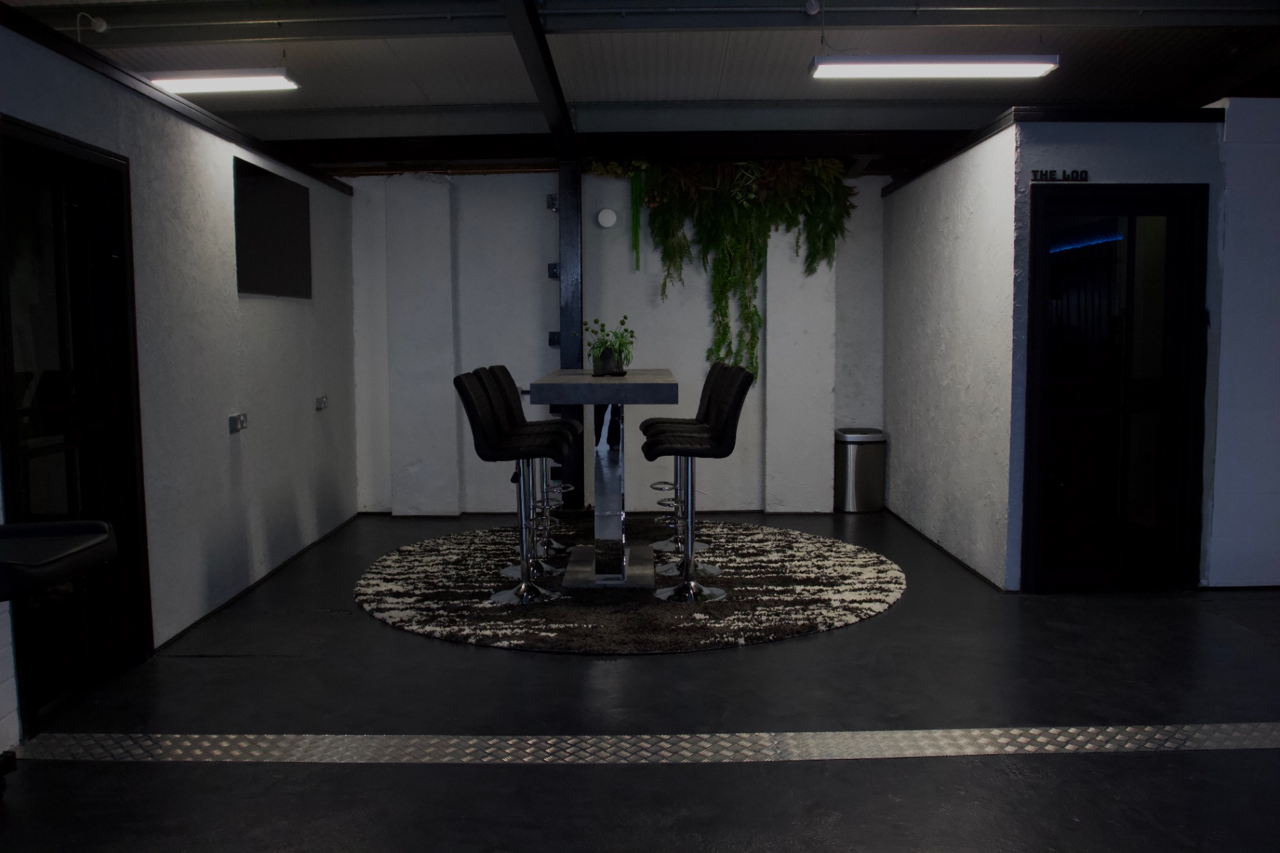 The meeting area at London's Glitch, with a concrete table and hanging greenery
