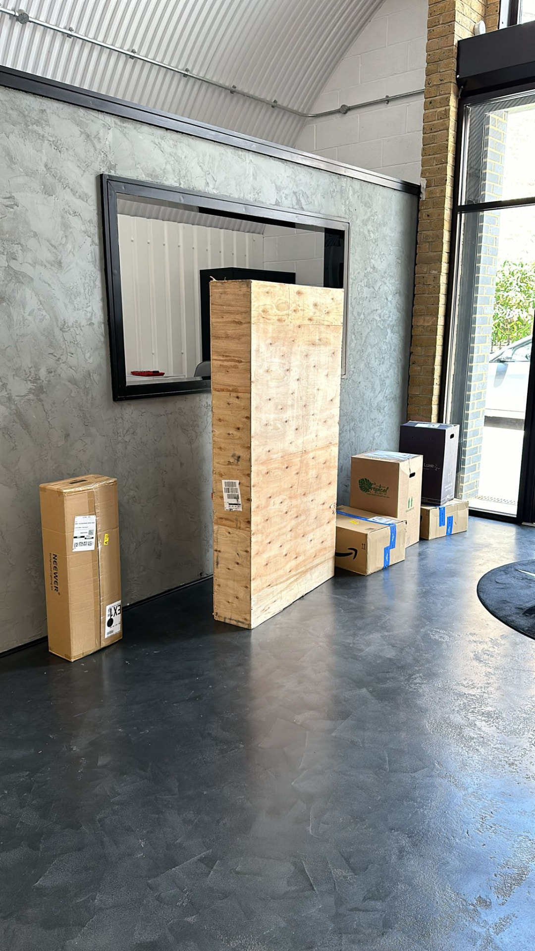 The new dark floor laid inside the arch with the first delivered fittings still boxed against the wall