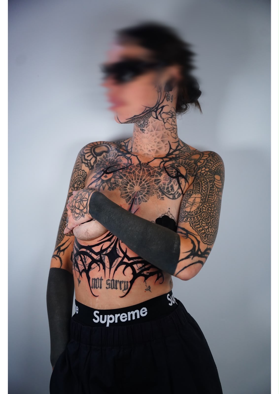 Full torso blackwork tattoo with mandala, blackout bands and cyber-tribal patterns