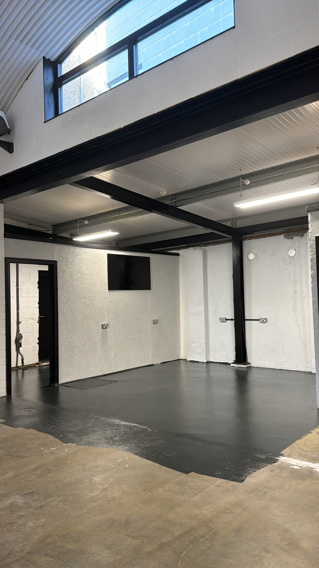 Finished black floor and clean walls in the back of the studio before furniture arrived
