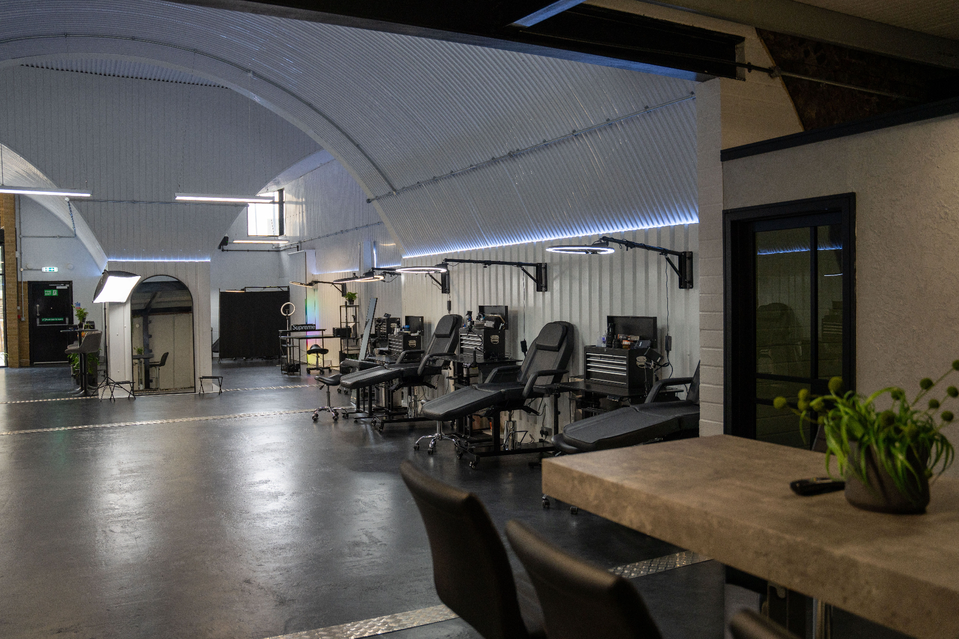 Wide view down the studio floor past the concrete meeting table and planting