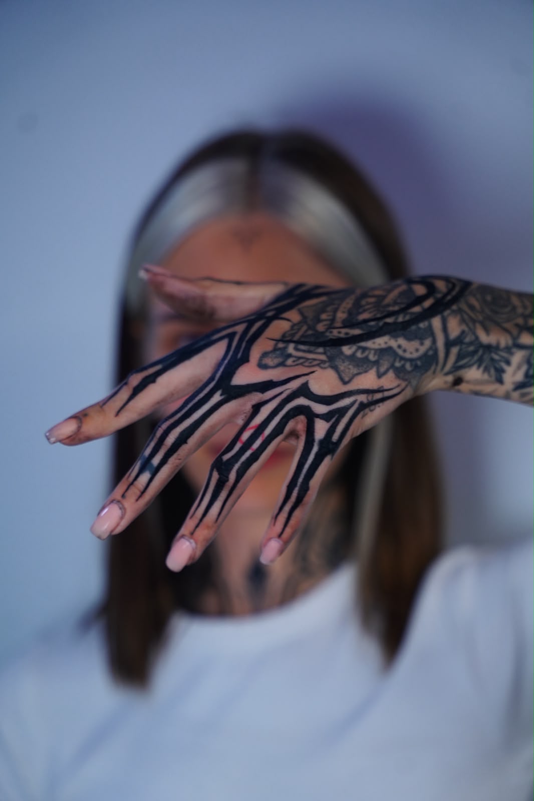 Cyber-tribal blackwork tattoo across the hand and fingers