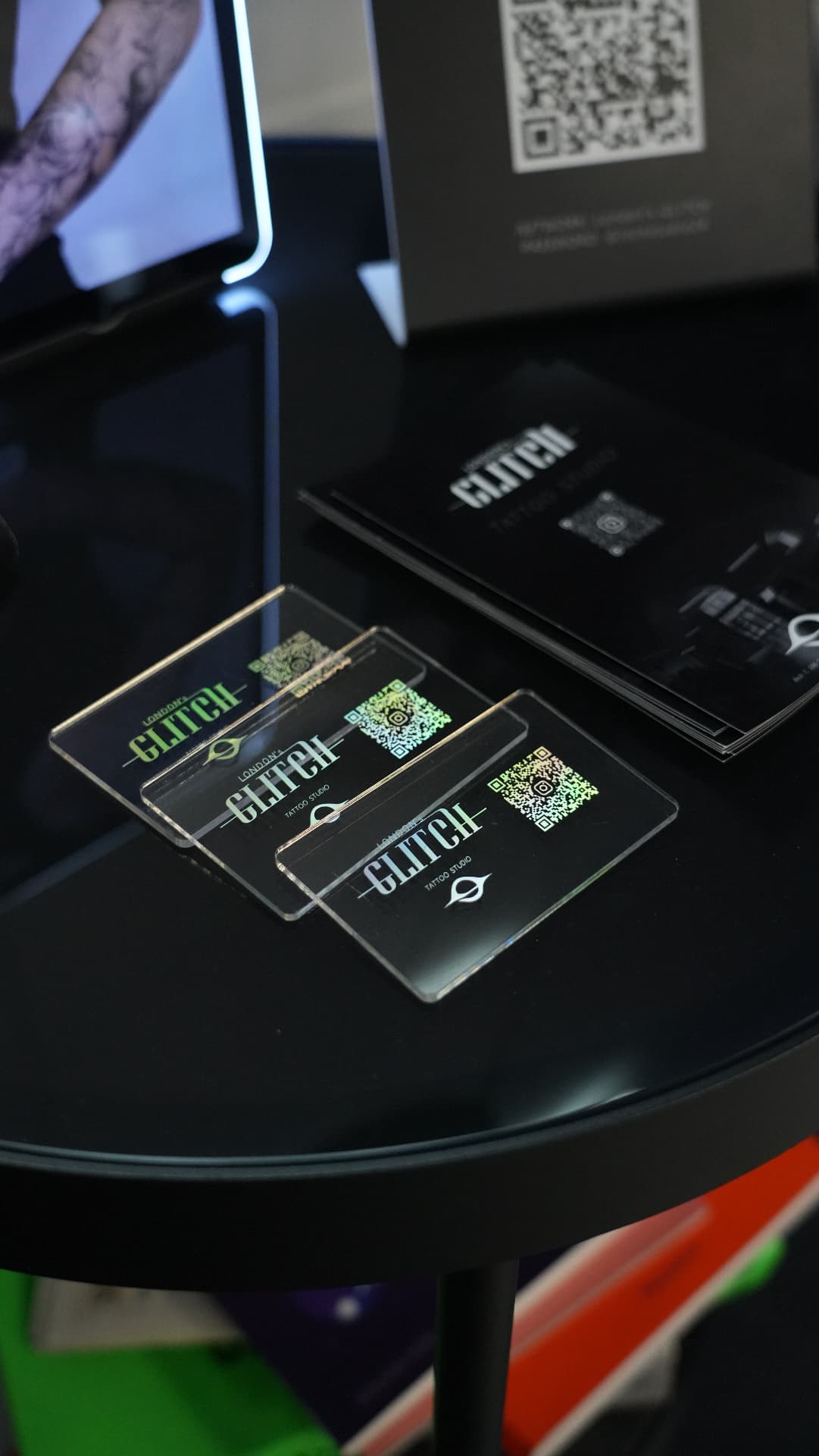 London's Glitch branded cards and booklets on a black reflective surface