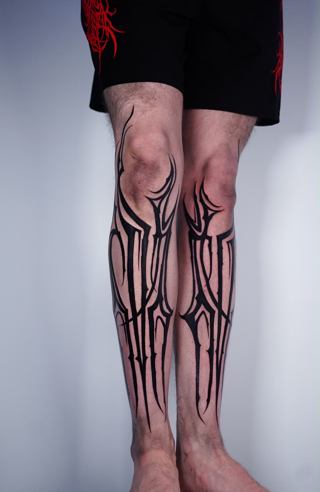 Neo-tribal blackwork tattoo on both shins
