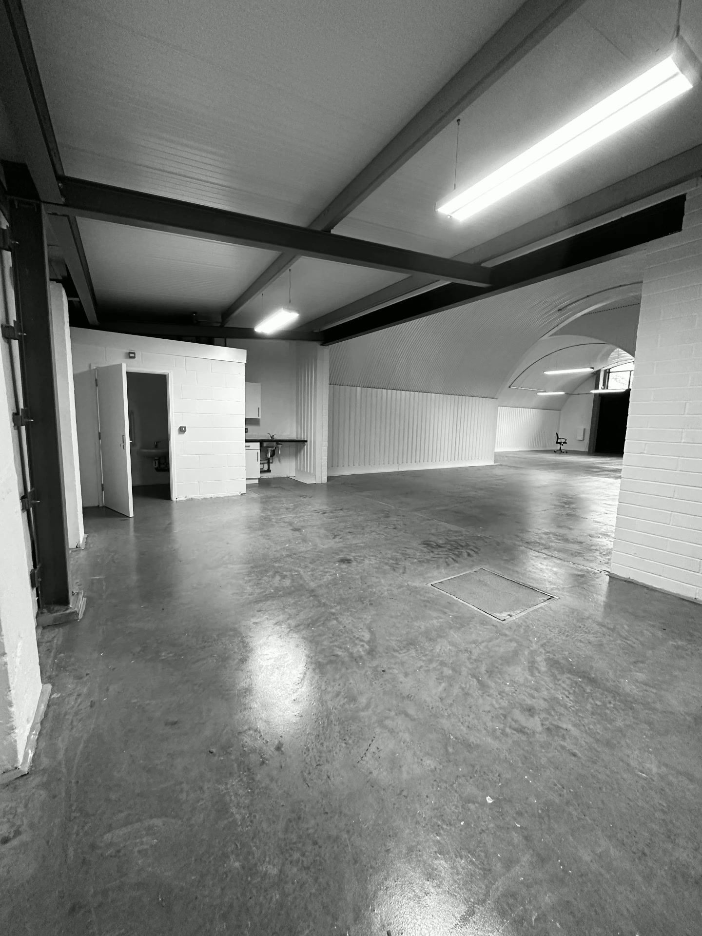 The empty 2,500 sq ft railway arch before work began, bare curved walls and an unfinished concrete floor